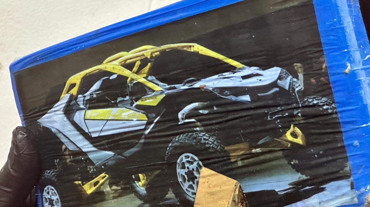A Monroe County Sheriff’s Office deputy holds a brick of cocaine with a photo of a dune buggy on it. The brick was one of 16 tourists found on the beach of a Florida Keys resort’s beach Sunday, Aug. 25, 2024, according to the sheriff’s office.