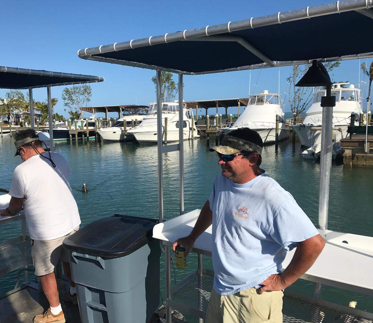 Paul Johnson, captain of the Gold Reserve charter boat, holds a beer and talks to his friends at the fish cleaning station at Post Card Inn and Marina on Windley Key Thursday, March 12, 2020.