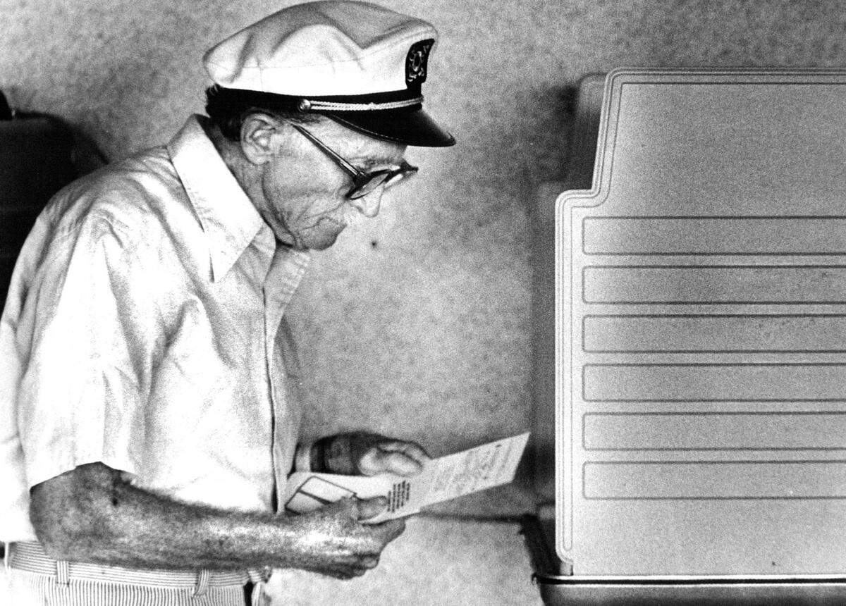 Bernie Heller checks his ballot in 1985 after making his selections before depositing her vote in absentee voting at Miami Beach City Hall.
