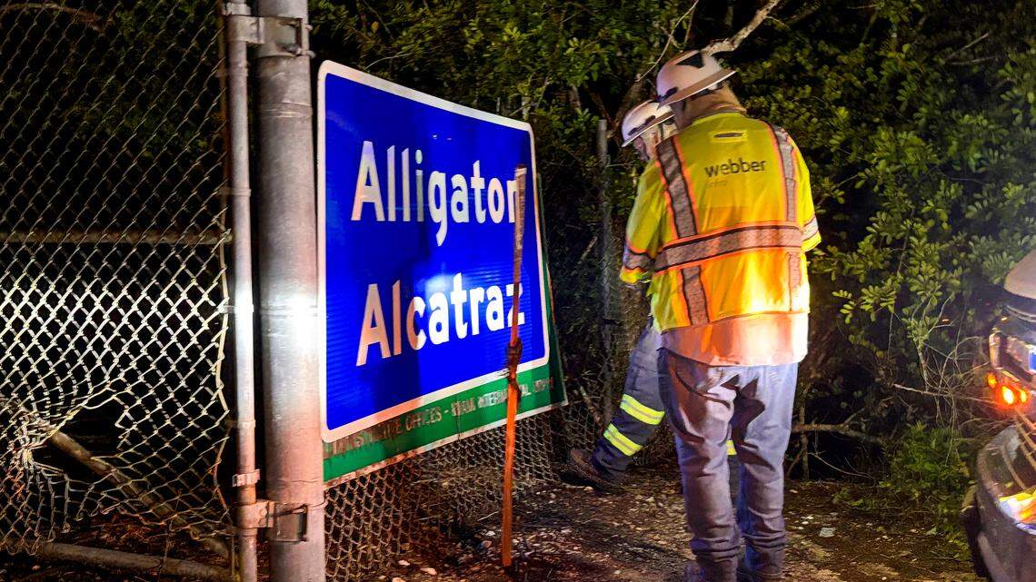Two workers installed a sign reading “Alligator Alcatraz” at the entrance, replacing the former “Dade-Collier Training and Transition Airport” signage at the site in Ochopee, Florida, on Wednesday, July 2, 2025.
