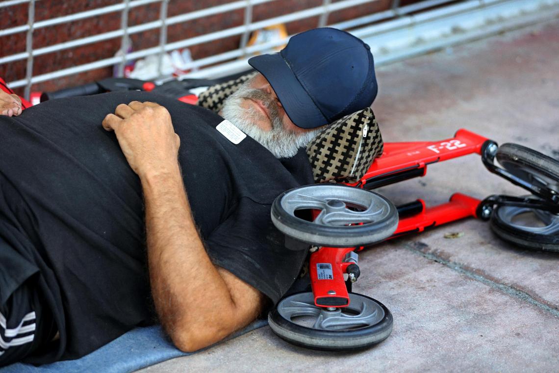 Reynol Perez, a homeless man living on North Miami Avenue in downtown Miami sleeps on the sidewalk after being vaccinated with the (J&J/Janssen) COVID-19 vaccine by medical staff with the Miami-Dade County Homeless Trust on Tuesday, May 25, 2021.