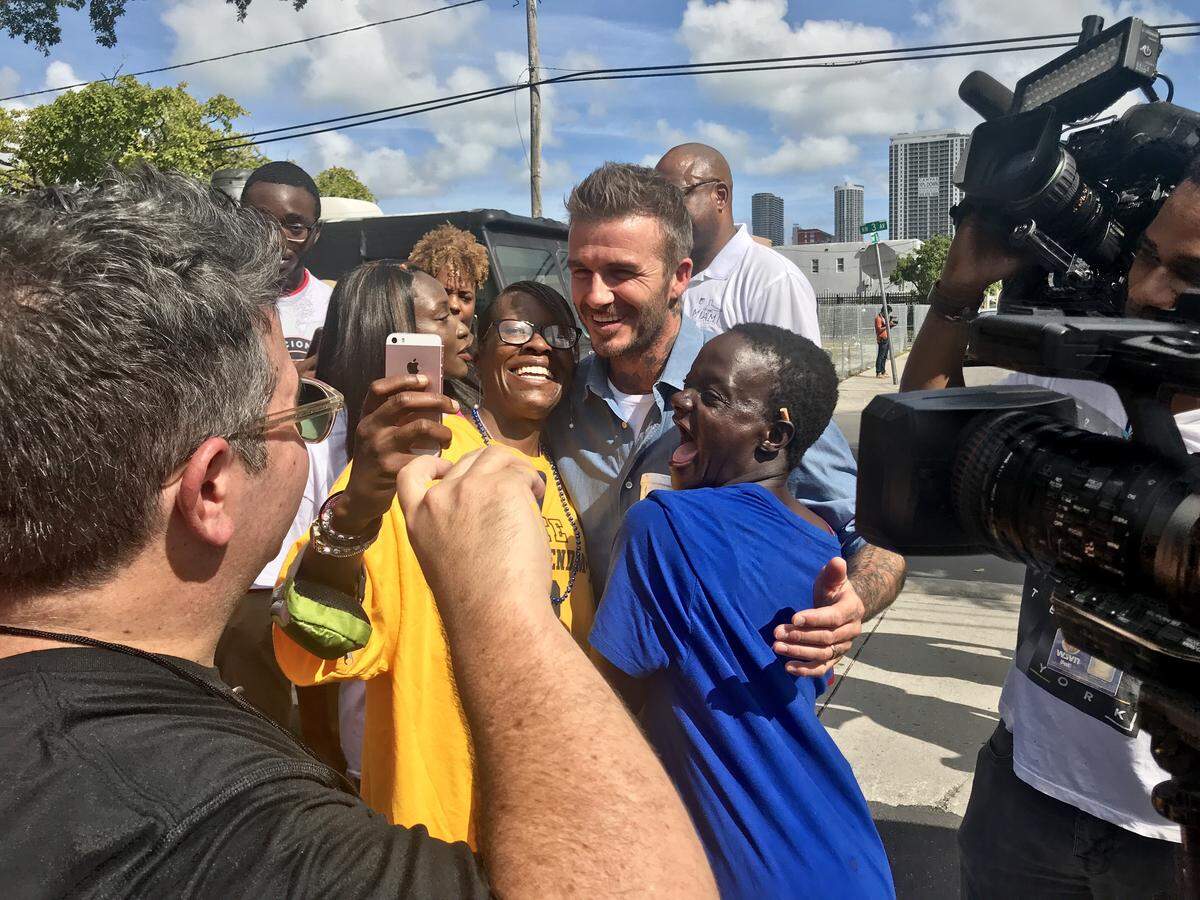 David Beckham posed with people outside polling places in Miami as he and partner Jorge Mas drummed up support for a plan to build a soccer stadium and commercial complex on a city-owned golf course, a proposal on the ballot Tuesday.