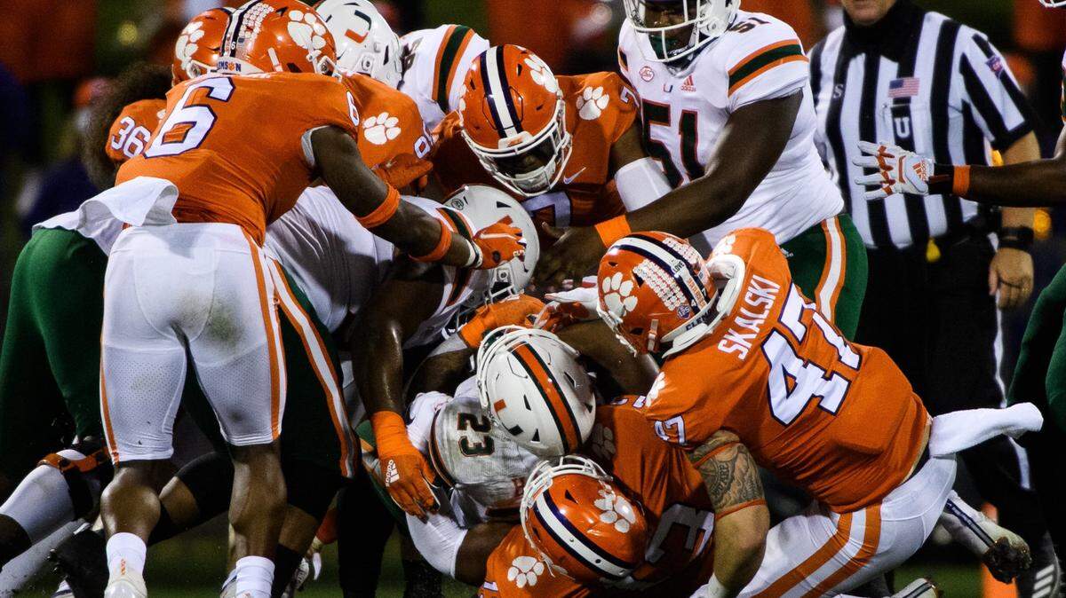 Miami running back Cam’Ron Harris (23) is tackled by Clemson defenders during their game at Memorial Stadium on Oct. 10, 2020, which the Tigers won. Photo by Ken Ruinard-USA TODAY Sports.