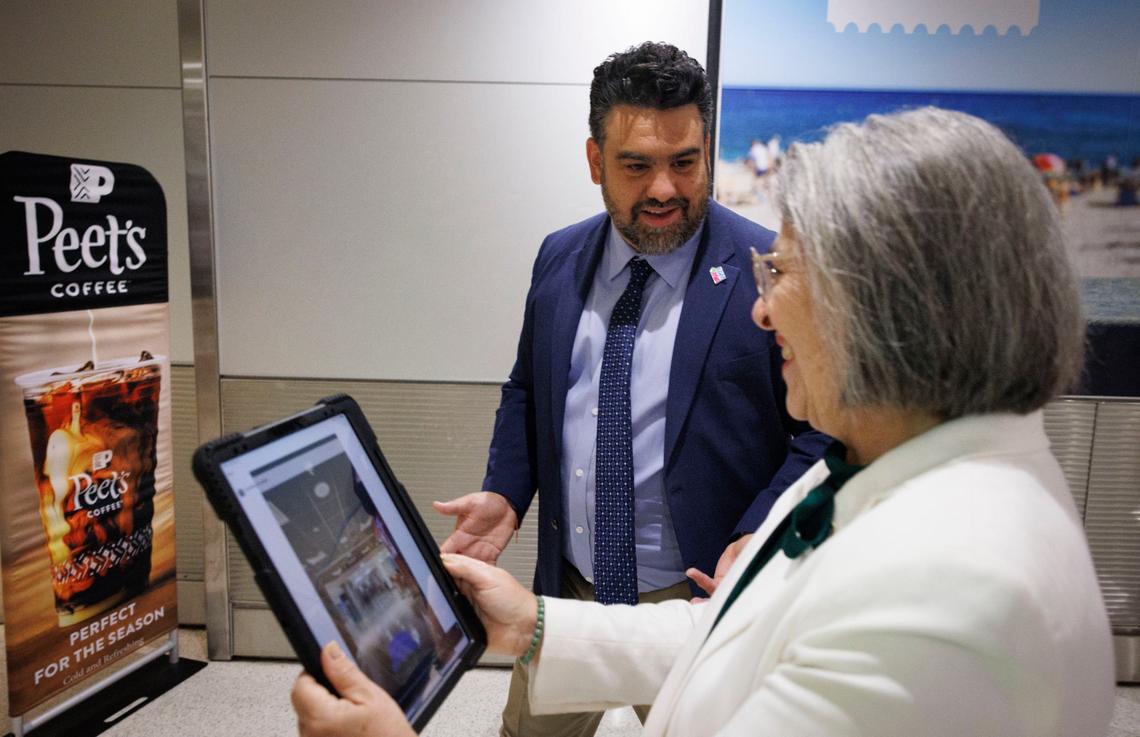 Mayor Daniella Levine Cava, right, is the first person to use RouteMe in a demonstration with Dimas Lipiz, RouteMe CEO and co-founder, center, on Thursday, Aug. 15, 2024, at Miami International Airport in Miami, Fla. RouteMe shows “step by step indoor way finding that uses AI to make virtually impossible to get lost,” said Dimas. It tracks the path and shows arrows on which way to go while you hold up your smart phone or tablet.