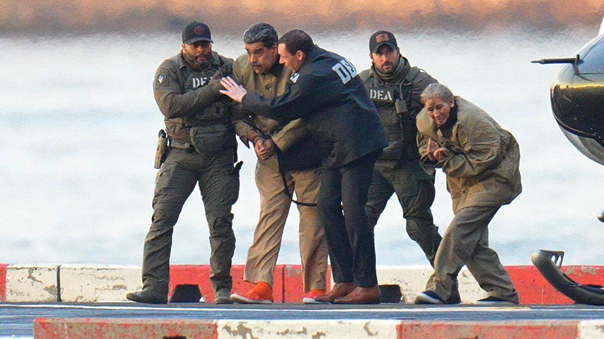 Nicolas Maduro and his wife, Cilia Flores, are seen in handcuffs after landing at a Manhattan helipad, escorted by heavily armed federal agents as they make their way into an armored car en route to a federal courthouse in Manhattan on Jan. 5 in New York City. 