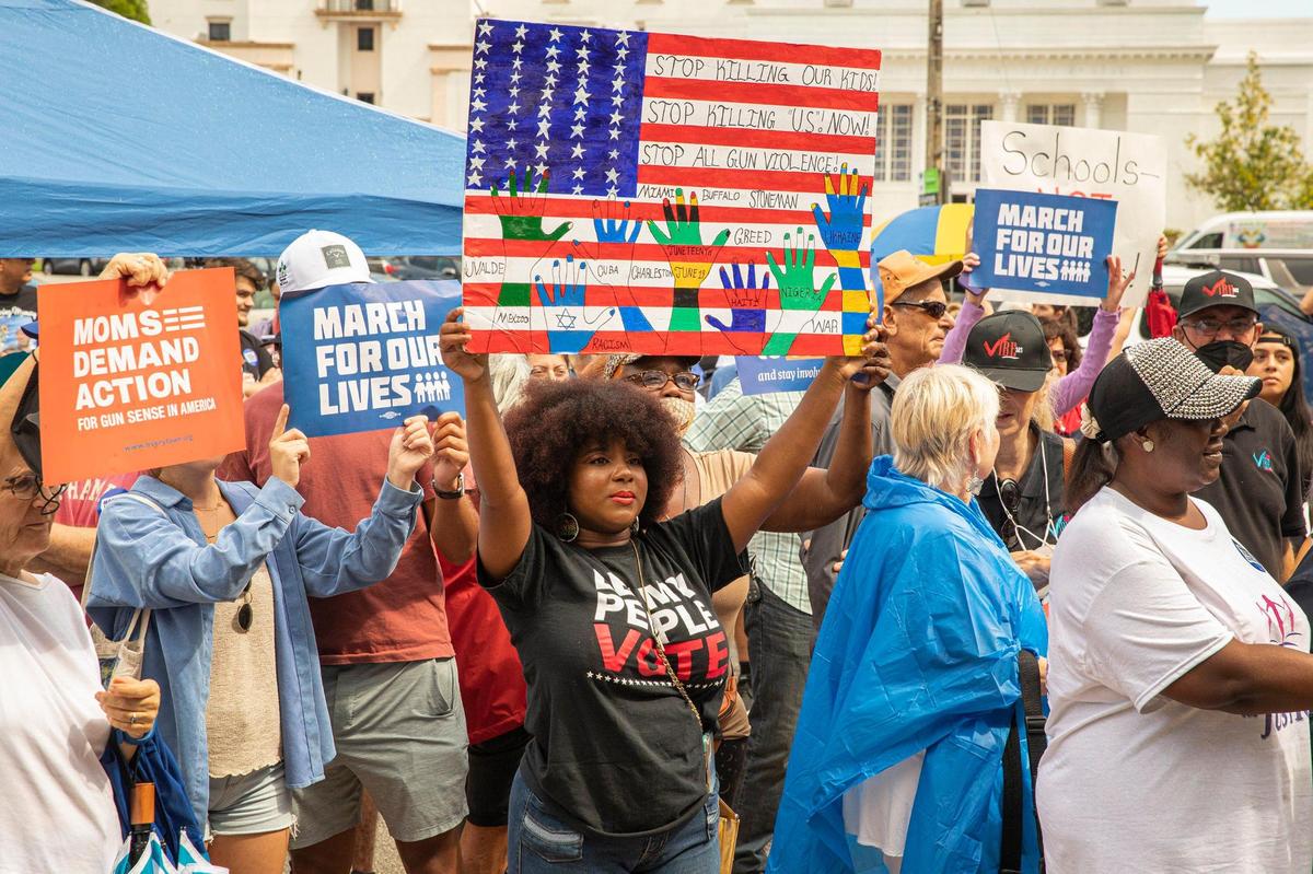 Shatera Coleman is seen holding a sign, among about 200 people from March for Our Lives and Moms Demand Action, who all gathered in front of City Hall on Sat., Jun. 11, 2022 in Coral Gables, Fla. to advocate for gun control. “Why do we have assault weapons that can massively kill people?” Coleman said. “The world needs a lot more healing.”