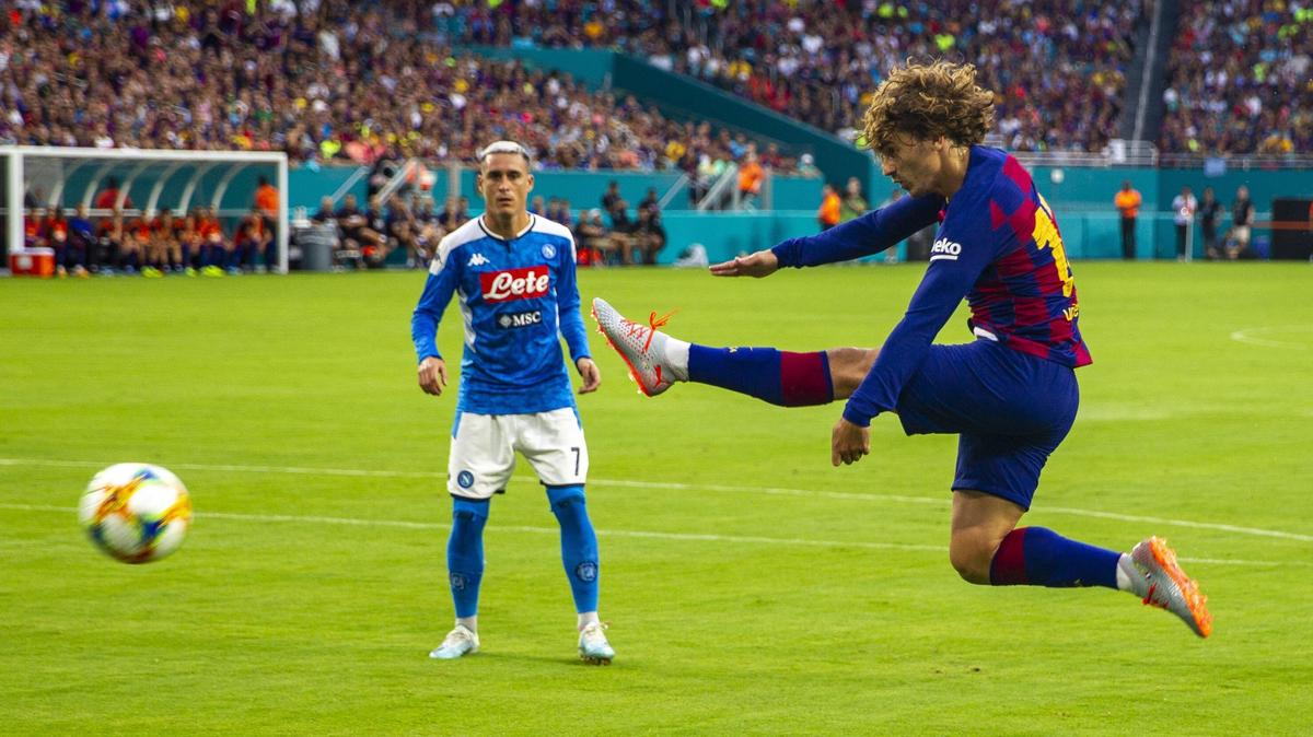 FC Barcelona forward Antoine Griezmann, right, takes a shot as SSC Napoli midfielder Jose Callejon watches during the first half of a La Liga Serie A game against Napoli at Hard Rock Stadium in Miami Gardens, Florida, on Wednesday, August 7, 2019.
