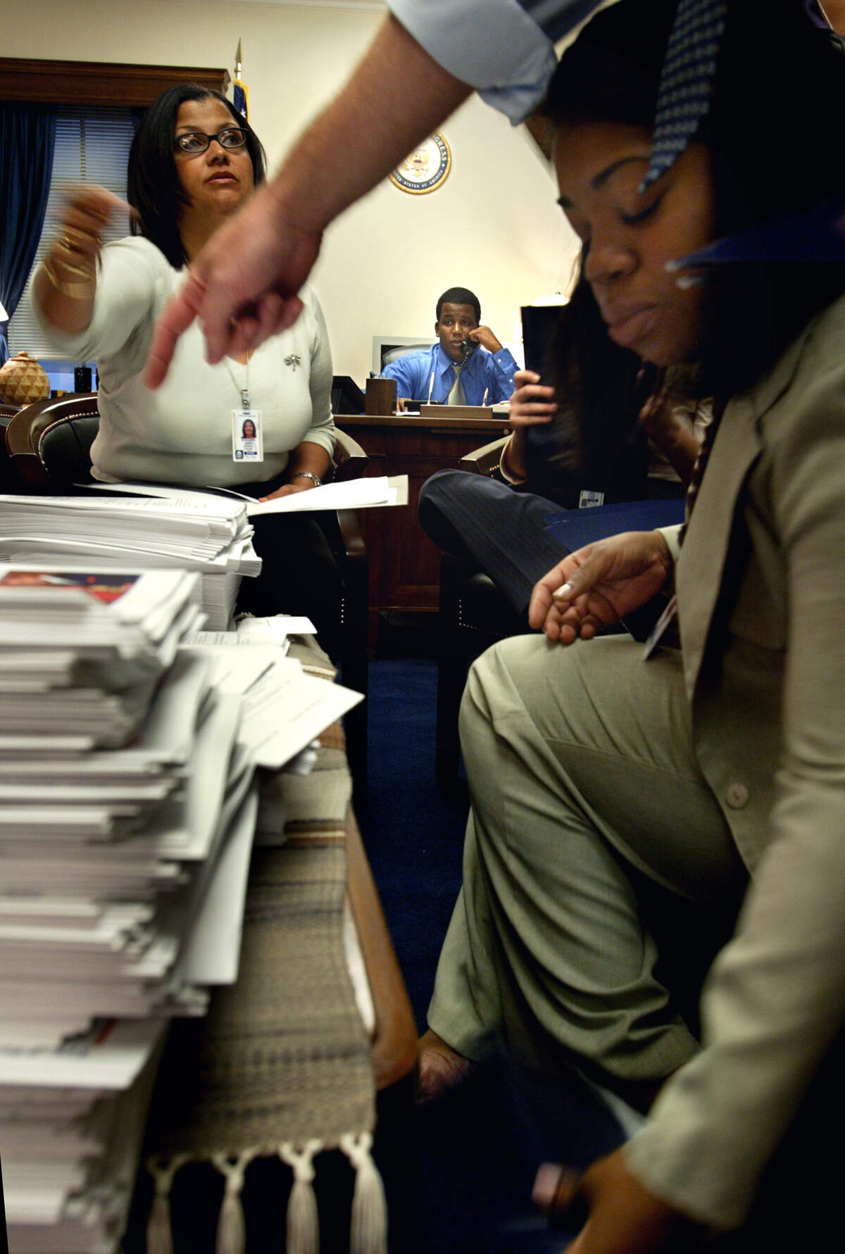Freshman Congressman Kendrick Meek talks on the phone in September 2003 as his staff prepared for a breakfast he was hosting as part of the Congressional Black Caucus. Staff members Shirlee Lafleur, right, and Regina Romero put folders together as Chief of Staff John Schelble points and directs.