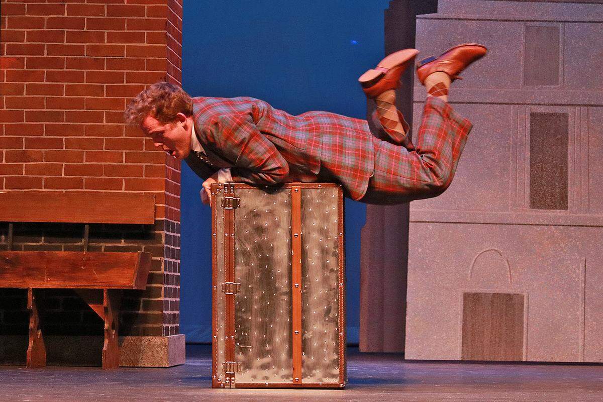 Wesley Slade wrestles with a trunk in the Actors’ Playhouse production of ‘One Man, Two Guvnors.’