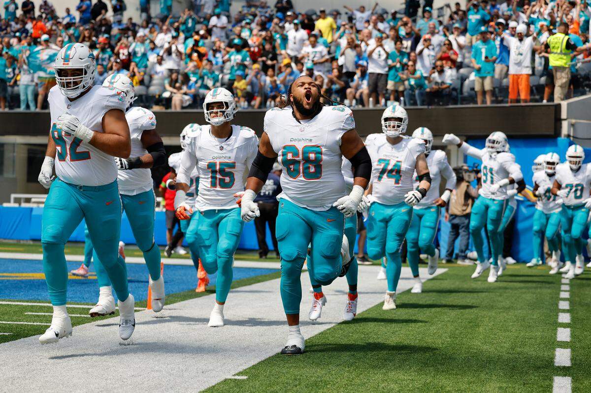 Miami Dolphins players Zach Sieler (92) Jaelan Phillips (15) and Robert Hunt (68) take the field before the start of an NFL football game against Los Angeles Chargers at SoFi Stadium in Inglewood, California on Sunday, September 10, 2023.
