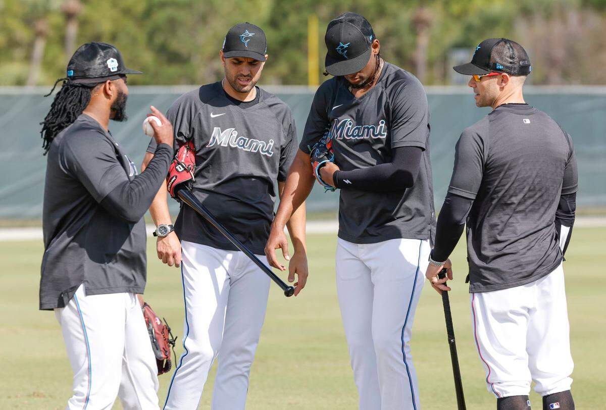 Miami Marlins pitchers Johnny Cueto (left) and Edward Cabrera (third from left) talk with bench coach Luis Urueta (second from left) and manager Skip Schumaker (far right) at Roger Dean Chevrolet Stadium in Jupiter, Florida on Thursday, February 16, 2023.