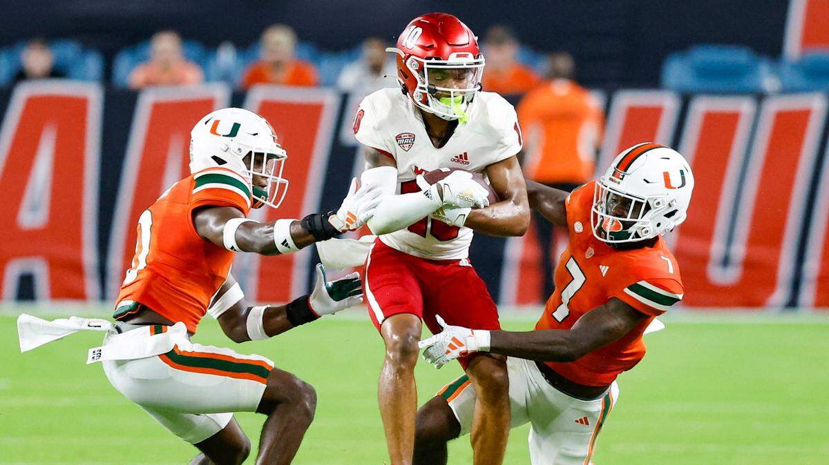 Miami Hurricanes cornerback Te’Cory Couch (0) and defensive back Davonte Brown (7) take down Miami of Ohio Redhawks wide receiver Gage Larvadain (10) in the second quarter at Hard Rock Stadium in Miami Gardens, Florida on Friday, September 1, 2023. 
