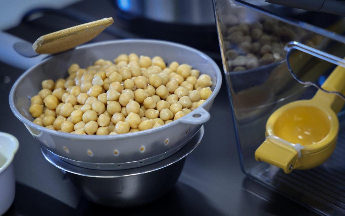 Common ingredient - chick peas is placed inside a strainer as a group of women prepare “Chick Peas with Lemon and Herbs” dish during a “Blue Zones” cooking class at the Overtown Youth Center on April 3, 2025, in Miami, Florida.