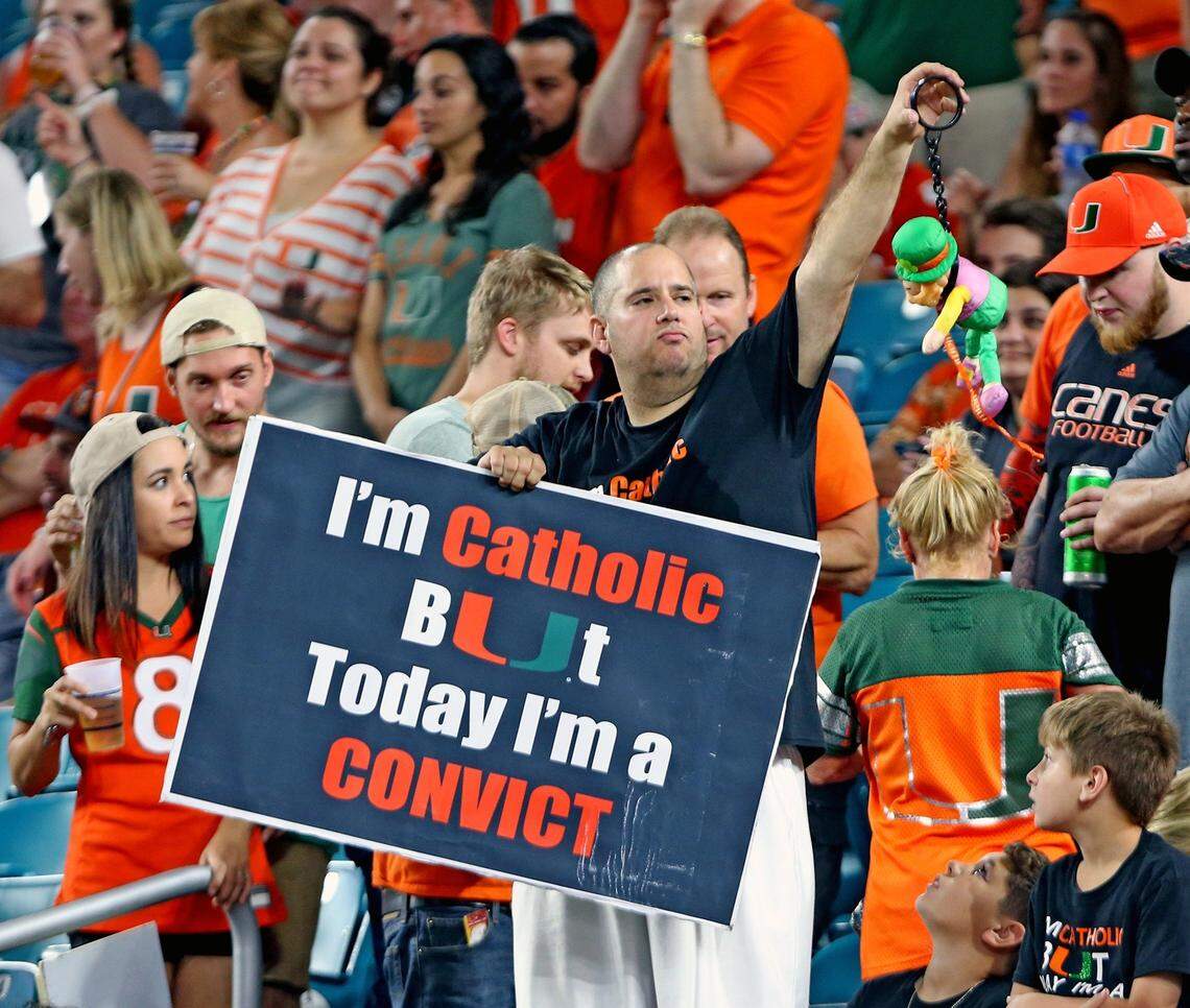 A Miami Hurricanes fan holds a "Catholic and Convict" sign as the Canes play Notre Dame at Hard Rock Stadium in Miami Gardens, Florida, November 11, 2017.