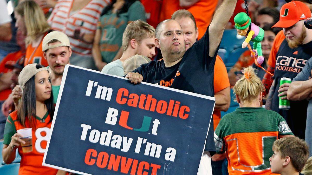 A Miami Hurricanes fan holds a "Catholic and Convict" sign as the Canes play Notre Dame at Hard Rock Stadium in Miami Gardens, Florida, November 11, 2017.