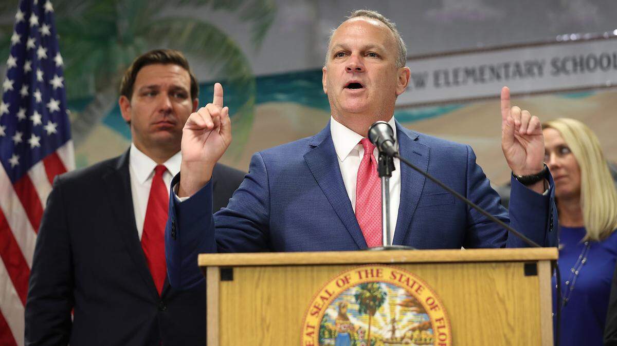 Florida Education Commissioner Richard Corcoran, center, is withholding funding from two school districts because they imposed mask mandates.