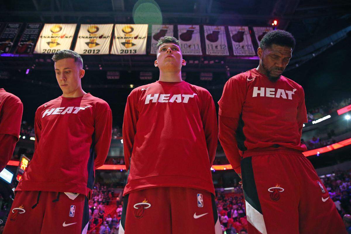 From left to right, Miami Heat players Duncan Robinson, Tyler Herro, and Udonis Haslem listen to the national anthem before the start of an NBA basketball regular season game against the Atlanta Hawks at AmericanAirlines Arena on Tuesday, October 29, 2019 in Miami.