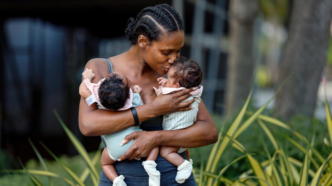 Downtown resident Jayme Callahan, 40, embraces her twin girls, Journey and Jayme, along the Fort Lauderdale Boardwalk on Thursday, April 24, 2025. There has been a dramatic increase in downtown Fort Lauderdale’s population of families with young children in recent years.