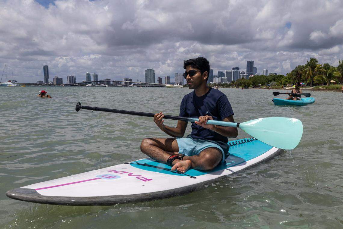 Boston natives Akash and Alisha move along the water on their paddle boards at Hobie Island Beach on Monday, September 1, 2025, in Key Biscayne, Fla.