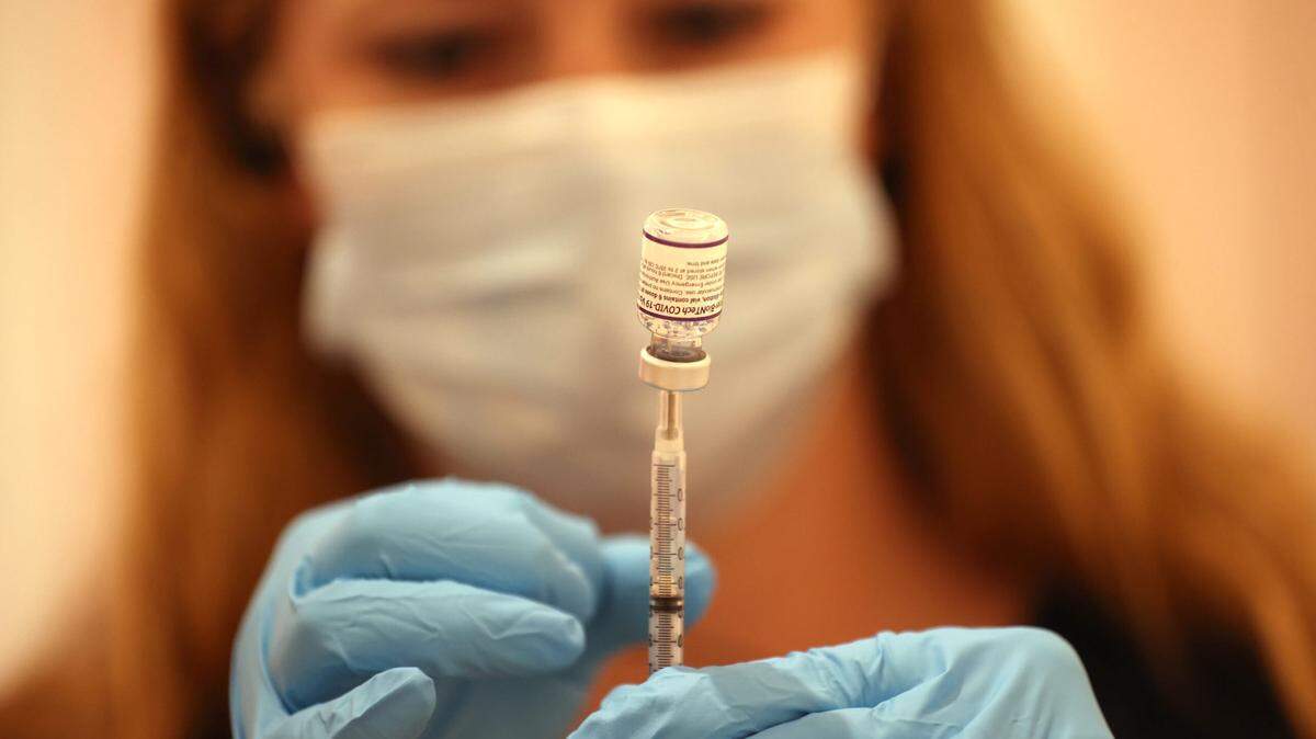 A California pharmacist fills a syringe with the Pfizer COVID-19 booster vaccination.