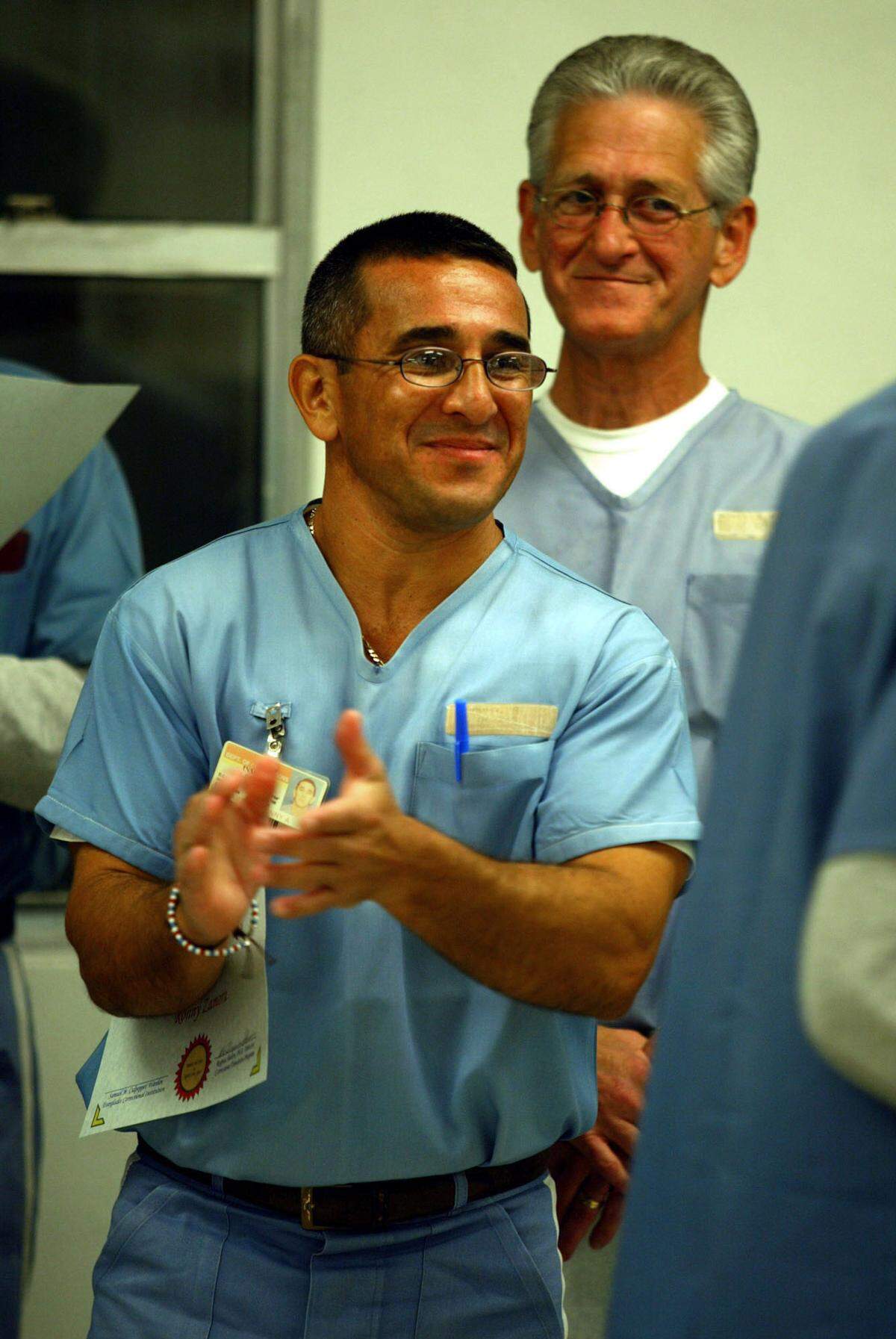 Ronny Zamora claps as a fellow inmate also accepts an award at the FIU Corrections Transition Program dinner at the Everglades Correctional Institute. The program helps inmates on life sentences to be successful if they get paroled.