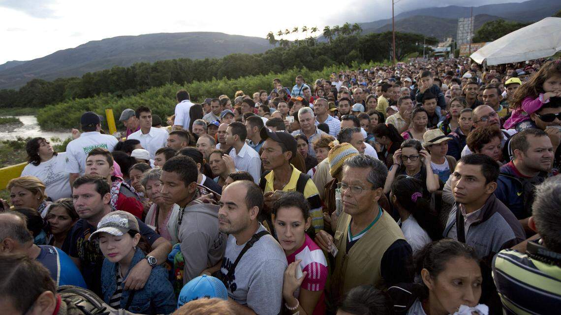 Venezuelans cross the Simon Bolivar bridge linking San Antonio del Tachira, Venezuela, with Cucuta, Colombia, to buy supplies, Sunday, July 17, 2016. Tens of thousands of Venezuelans crossed the border into Colombia on Sunday to hunt for food and medicine that are in short supply at home. It's the second weekend in a row that Venezuela’s government has opened the long-closed border connecting Venezuela to Colombia, and by 6 a.m., a line of would-be shoppers snaked through the entire town of San Antonio del Tachira. (AP Photo/Ariana Cubillos)