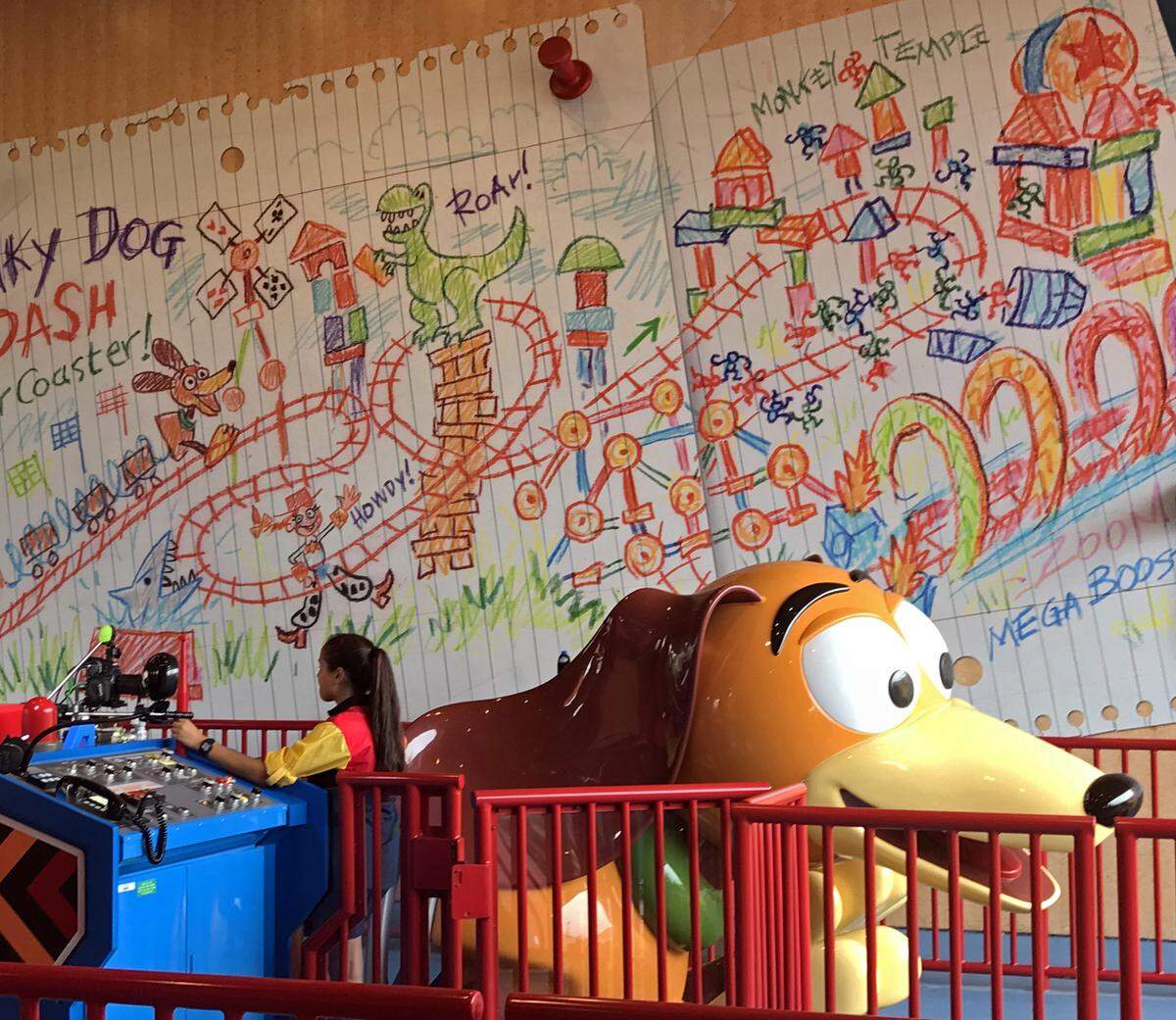 Andy's drawings and notes about Slinky Dog Dash are tacked up on the wall of the roller coaster's loading area.