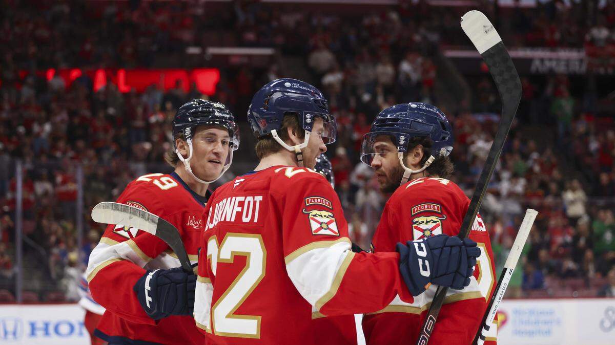 Florida Panthers left wing Cole Reinhardt (29), left, celebrates with Florida Panthers Tobias Bjornfot (22) and other teammates after scoring a goal during the first period of a game on Monday, April 13, 2026, at Amerant Bank Arena in Miami, Fla.