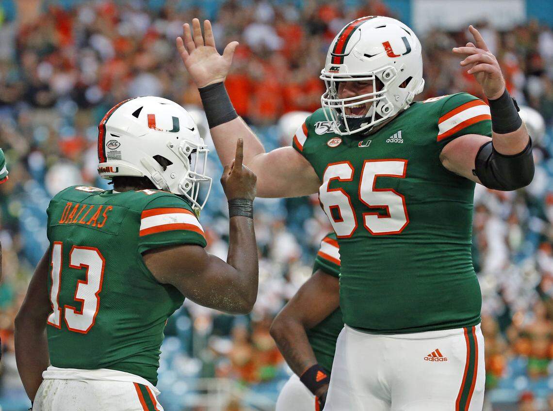 Miami Hurricanes running back DeeJay Dallas (13) celebrates with offensive lineman Corey Gaynor (65) after a five yard rush for a touchdown in the first quarter as the University of Miami Hurricanes host the Louisville Cardinals on Saturday, November 9, 2019.