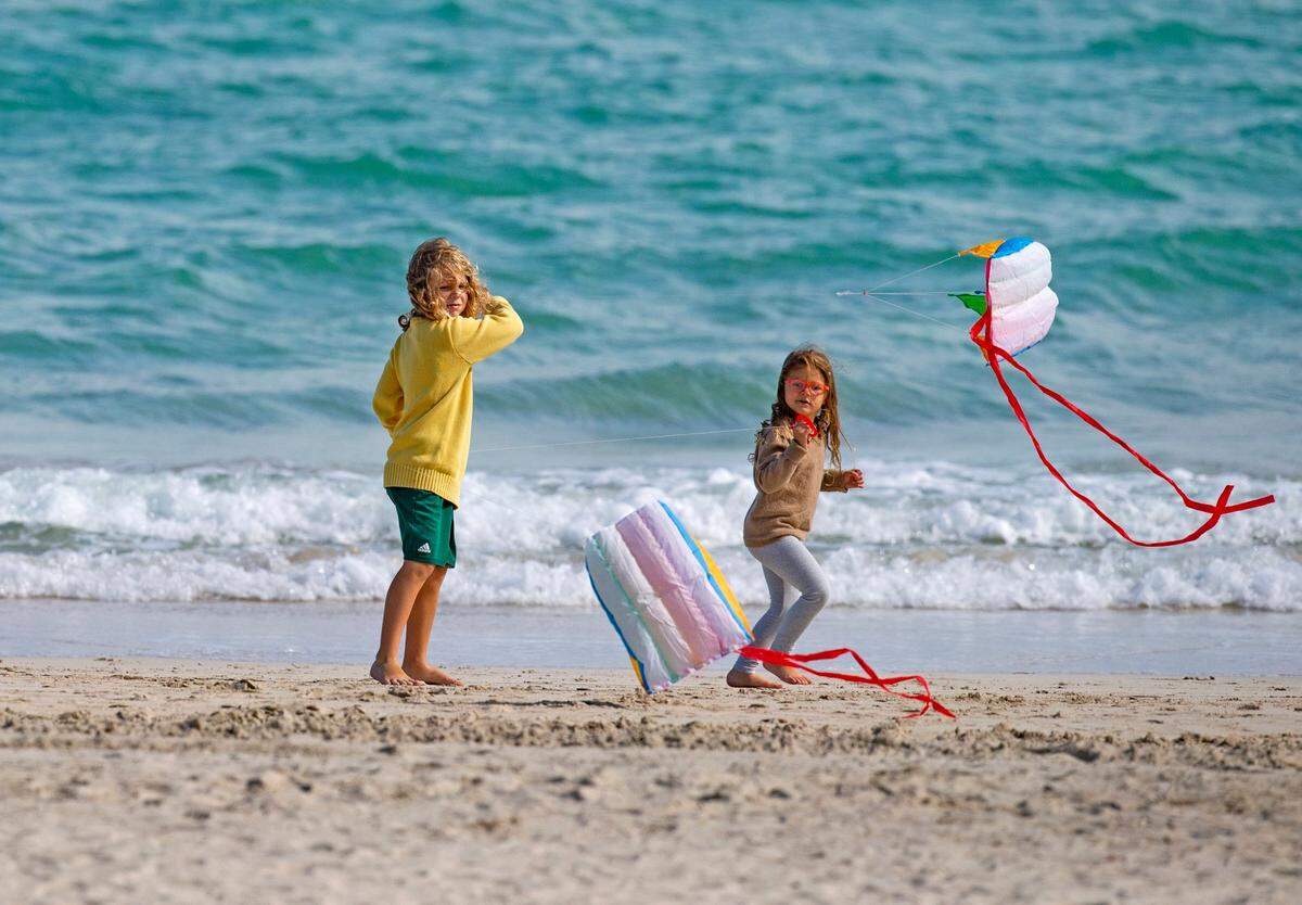 Noah, 6, and his sister Chloe, 4, fly kites while enjoying the cool weather at South Pointe Beach on Thursday, December 10, 2020, in Miami Beach, Florida.