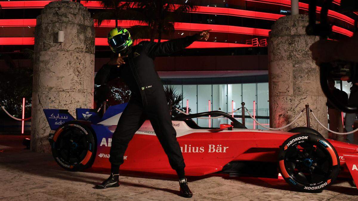 Retired Jamaican sprinter Usain Bolt shows his iconic pose while wearing a racing suit in front of the ABB Formula E racecar as the Miami Tower lights up during an event hosted by title partner ABB in downtown Miami on Thursday, Jan. 29, 2026.