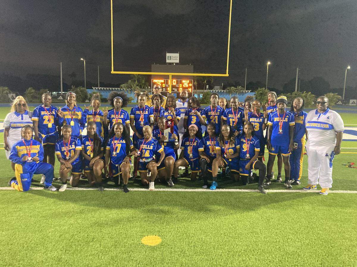 Miami Northwestern flag football players and coaches pose for a team picture after beating Miami Palmetto in double overtime to win their first GMAC championship on Monday night at Traz Powell Stadium.