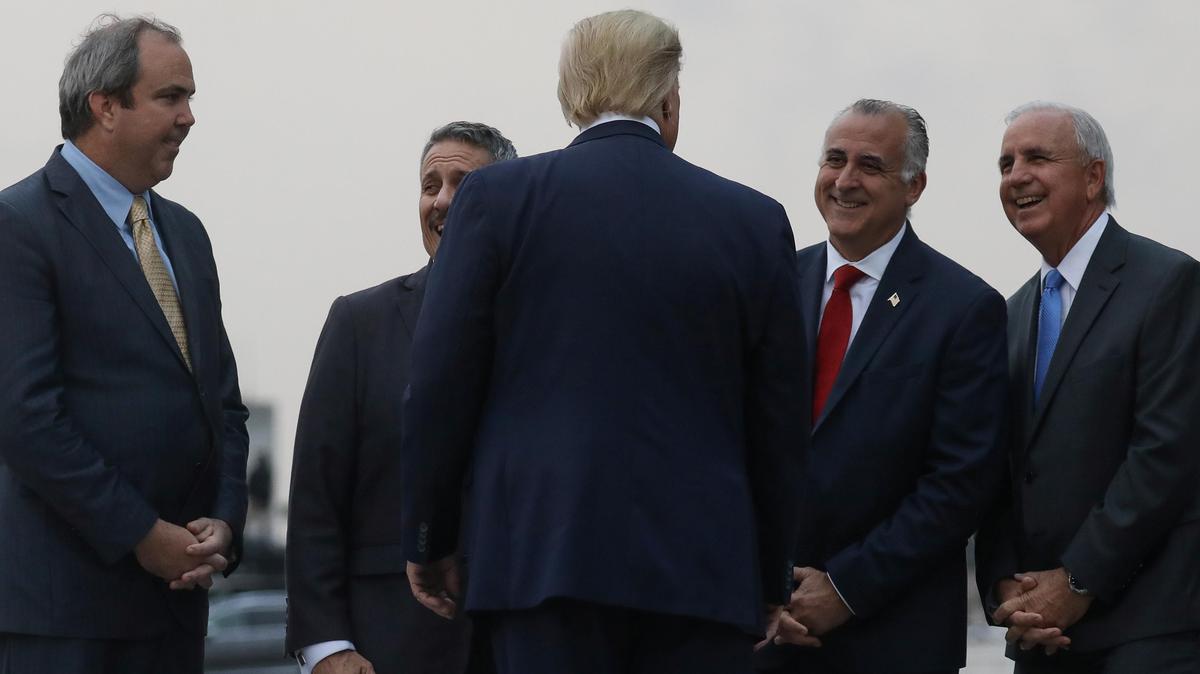 U.S. President Donald Trump greets Chairman of the Republican Party of Florida Joe Gruters, Commissioner of Miami-Dade County District 12 Jose Diaz, Commissioner of Miami-Dade County District 13 Esteban Bovo Jr. and Miami-Dade Mayor Carlos Gimenez as he arrives at Miami International Airport on January 23, 2020.