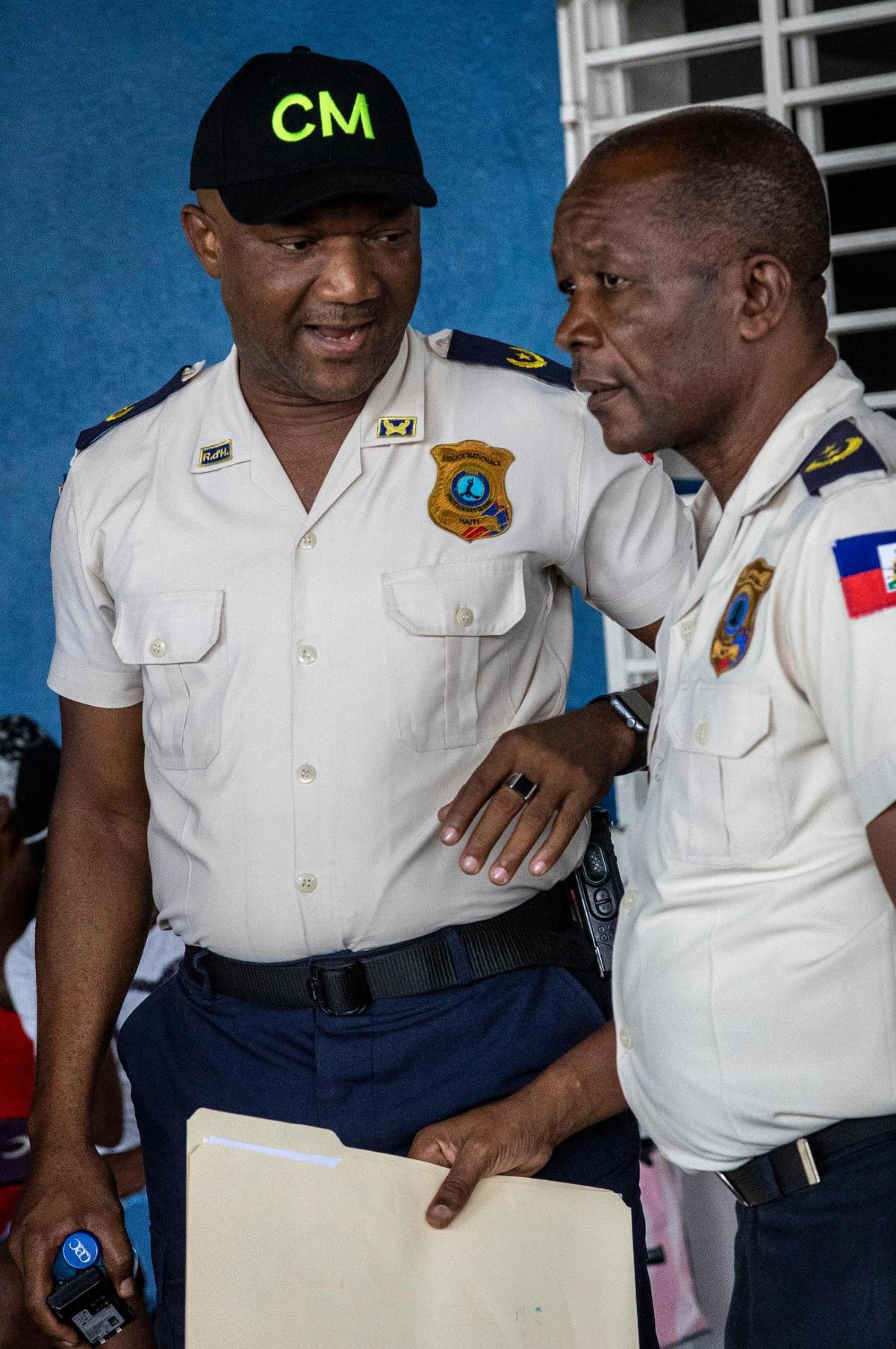 Livenston Gauthier, left, a 27-year-veteran of the Haiti National Police, speaks to Roger Lamartinière, the then-head of the Croix-des-Bouquets police station. In 2022, both men had worked together to stave off control of the eastern region of Port-au-Prince by violent gangs.