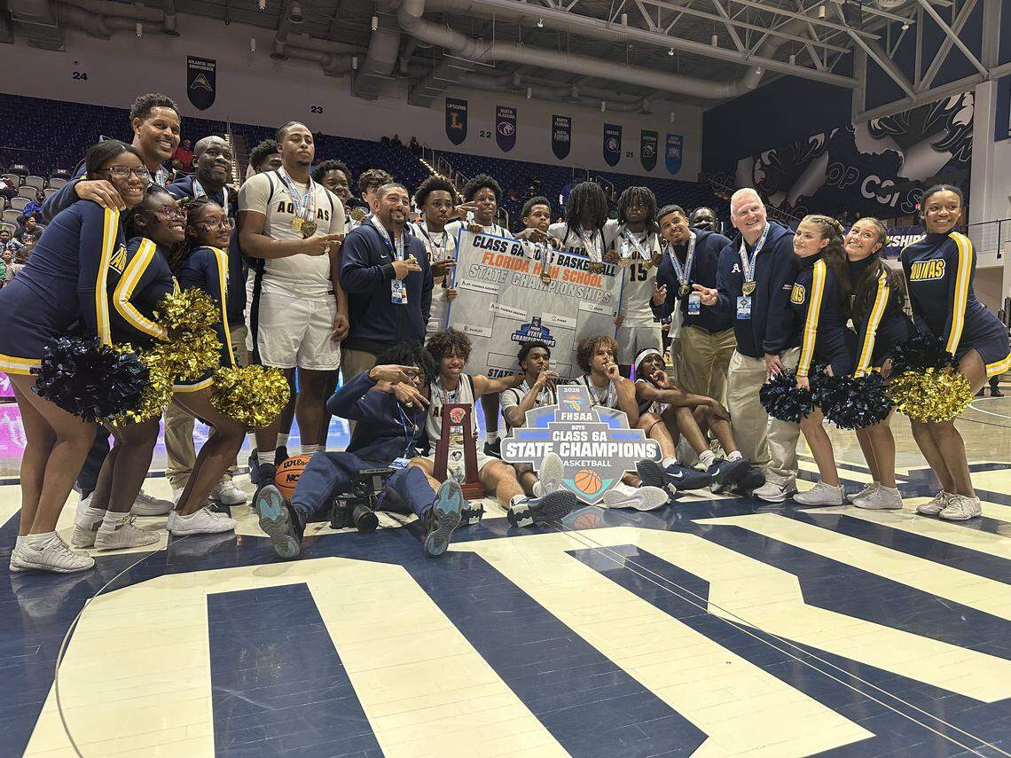 St. Thomas Aquinas’ boys’ basketball team celebrates after winning their second consecutive state championship on Saturday at UNF Arena in Jacksonville, Fla.
