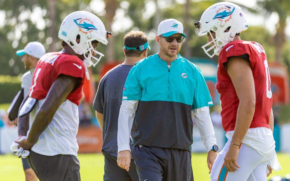 Miami Dolphins pass game coordinator Darrell Bevell on the field with quarterbacks Tua Tagovailoa (left) and Zach Wilson (right) during practice at the Miami Dolphins Training Camp.