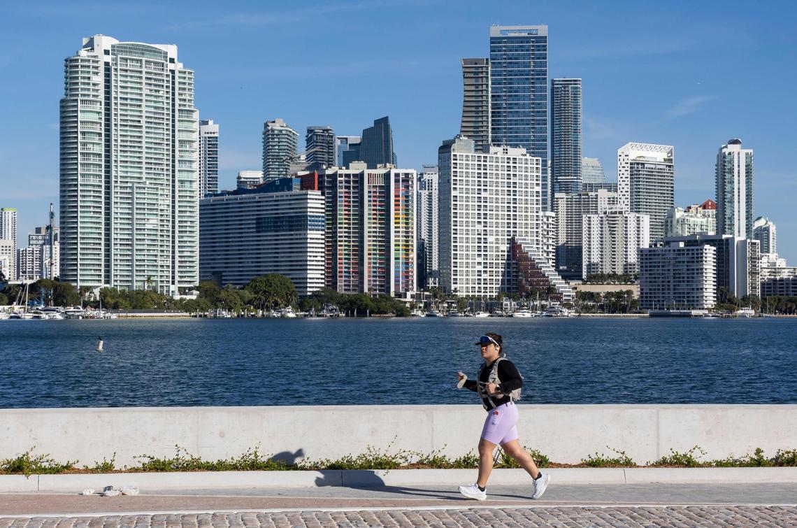 A woman makes her way down a pedestrian path at Hobie Island Beach Park North on Saturday, Dec. 21, 2024, in Miami, Fla. The park recently reopened after being closed since 2017 due to damage caused by Hurricane Irma. It now features a panoramic view of Brickell, a higher elevation, a revitalized shoreline, a beach, and separated bike and pedestrian paths.