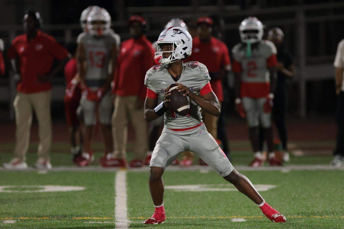 Chaminade-Madonna Lions quarterback Malik Leonard (14) looks for a passing option against Trinity Christian Academy during the second half of a Class 1A football state semifinal game at Chaminade-Madonna College Preparatory on Friday, Dec. 5, 2025 in Hollywood, Fla.