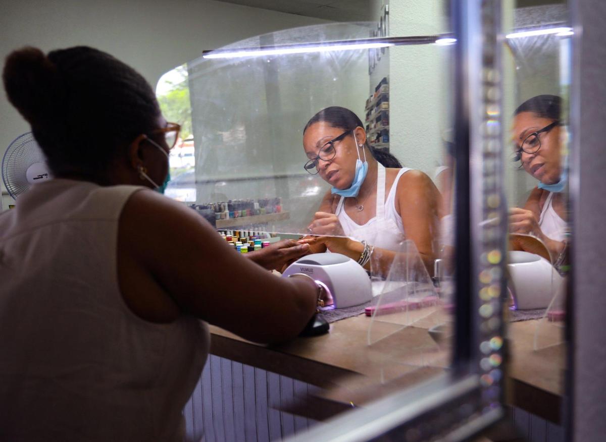 Michelle Davis, owner of Spoilt, a Miami Gardens nail salon, does the nails of Deniese Demontagnac, left, on Thursday, August 12, 2021.