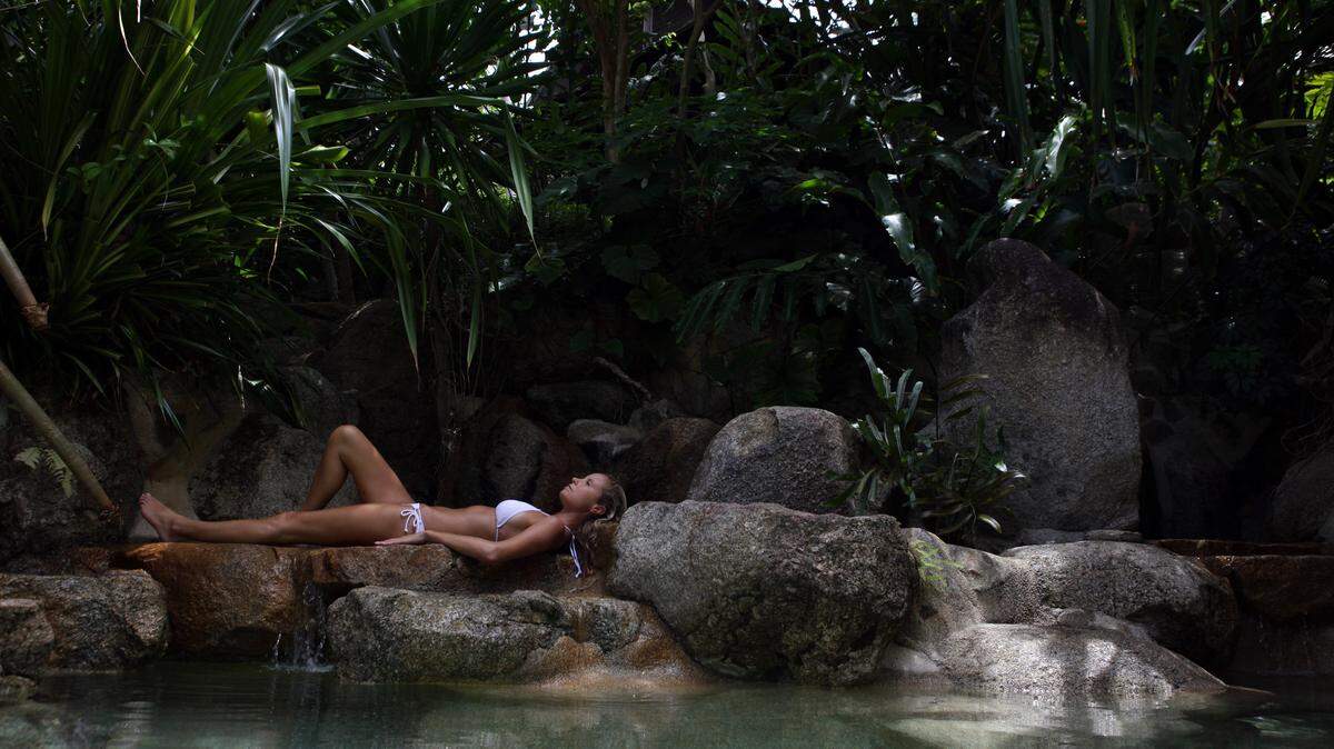 A woman rests along the rocks at the edge of the swimming pool at Kamalaya Wellness Sanctuary June 18, 2012 .