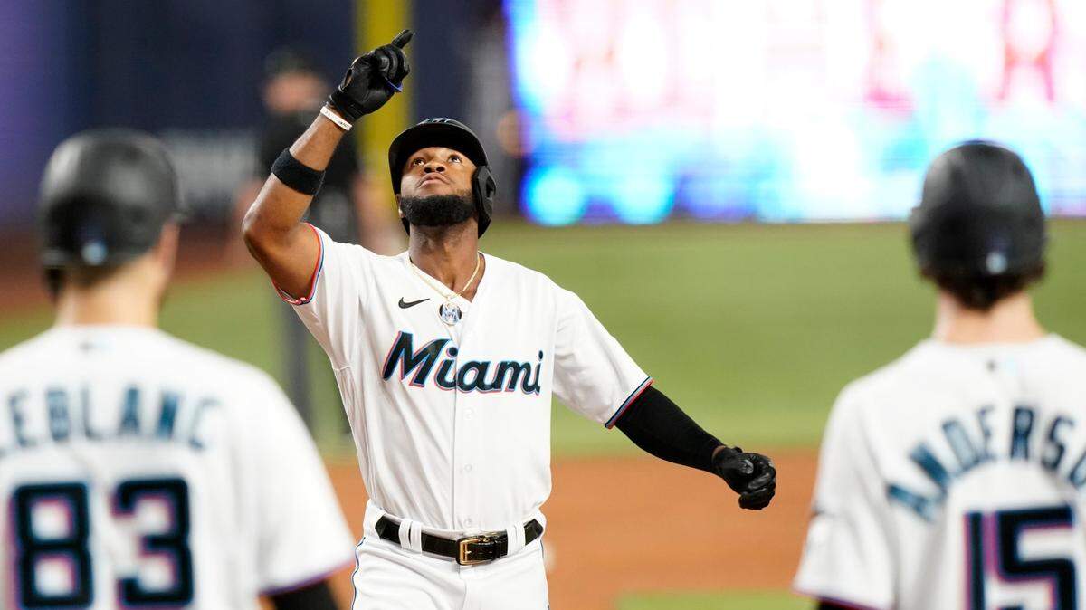 Miami Marlins’ Bryan De La Cruz, center, crosses the plate to score after hitting a grand slam during the third inning of a baseball game against the Chicago Cubs, Monday, Sept. 19, 2022, in Miami. (AP Photo/Lynne Sladky)