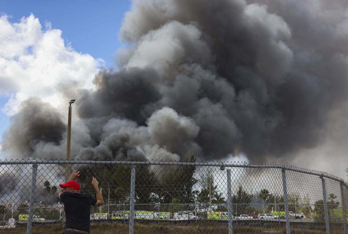 Jorge Rodriguez, truck driver, watches the smoke billow out during a warehouse fire on Thursday, March 5, 2026, in Miami Gardens, Fla. ‘My truck and everything is inside,’ said Rodriguez. ‘There’s artificial grass in there and once that goes up and just woooshhh,’ said Rodriguez. 