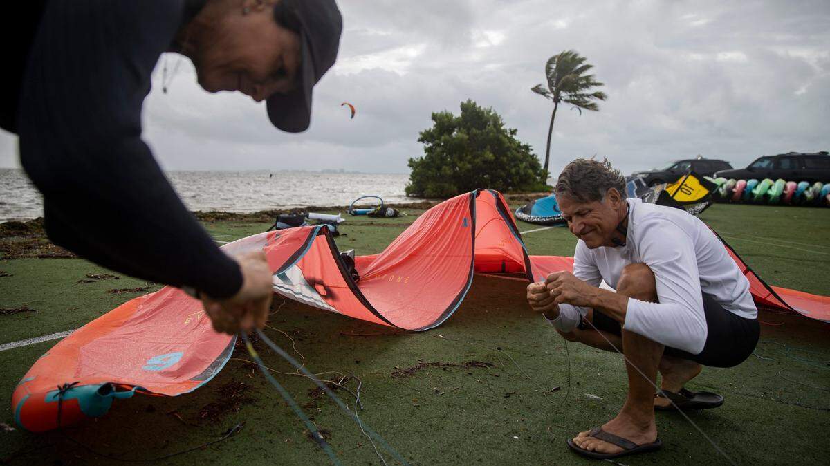 David and Beatrize Brayer, from Pinecrest, run their lines before riding kite boards as raining weather makes its way over Matheson Hammock Park on Tuesday, April 11, 2023, in Coral Gables, Fla.