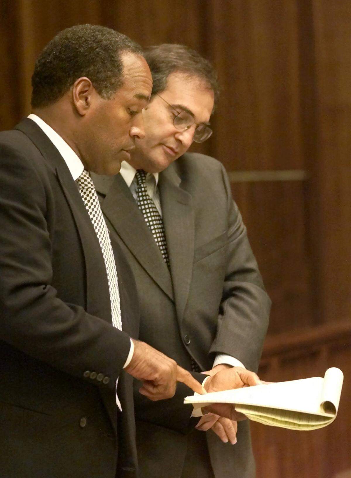 O.J. Simpson, a la izquierda, habla con su abogado Lee Cohn, en el Tribunal de Circuito de Miami-Dade, el viernes 12 de octubre de 2001, durante el cuarto día de selección del jurado para el juicio de Simpson por cargos de robo de automóvil y agresión.