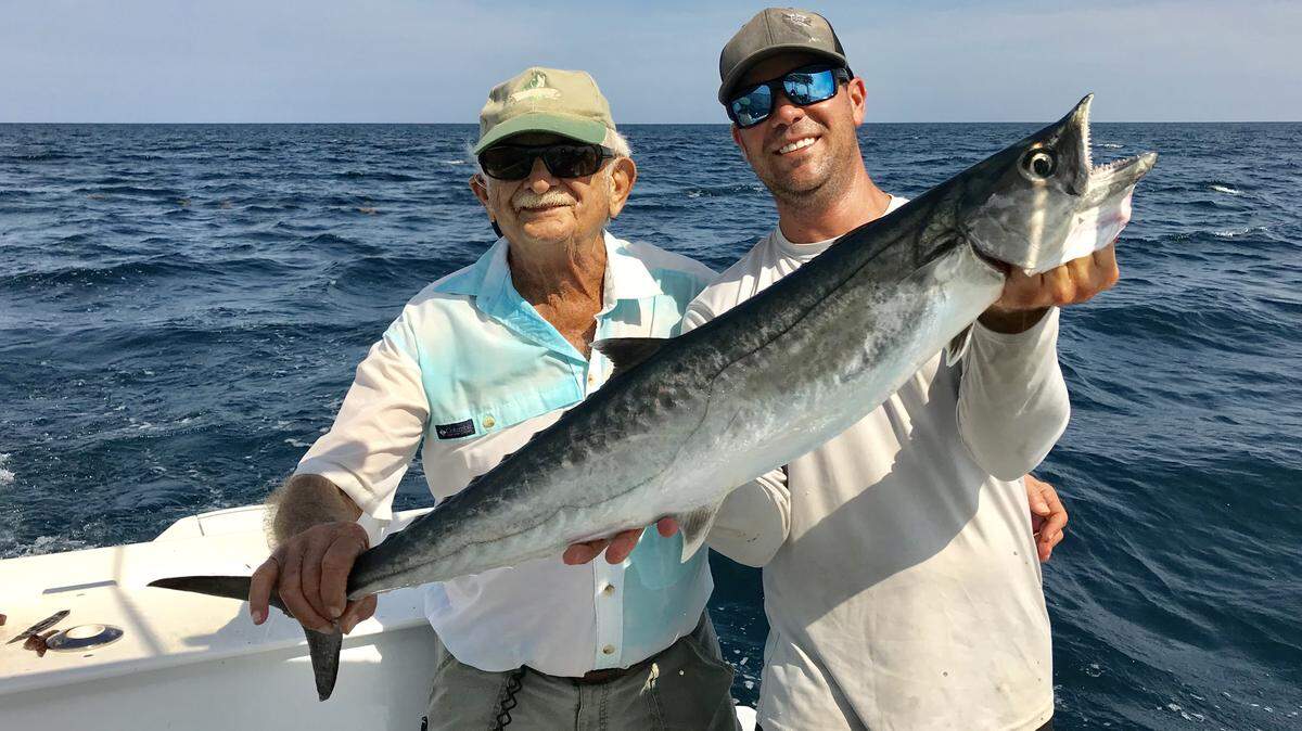 Lloyd Waters, left, and Capt. Chris Lemieux hold a 13-pound kingfish that Waters caught trolling bonito strips with Sea Witches in 90-110 feet of water off Boynton Beach.