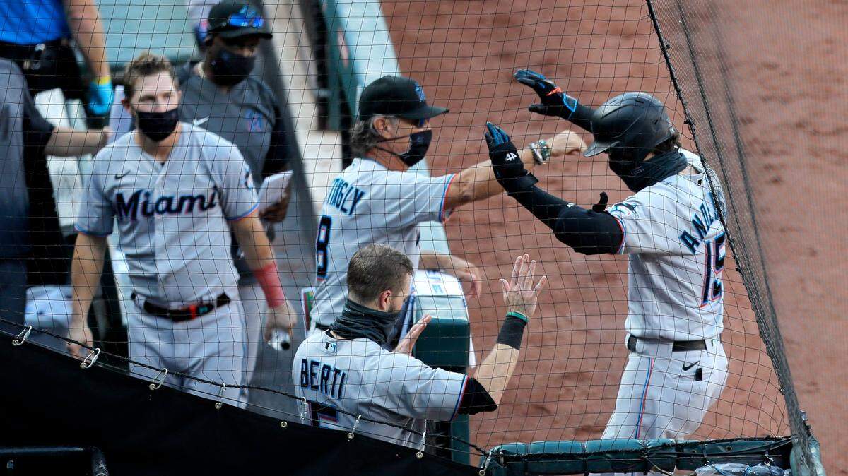 Miami Marlins’ Brian Anderson, right, is greeted in the dugout after hitting a solo home run off Baltimore Orioles starting pitcher Alex Cobb during the fourth inning in game one of a baseball double-header, Wednesday, Aug. 5, 2020, in Baltimore.