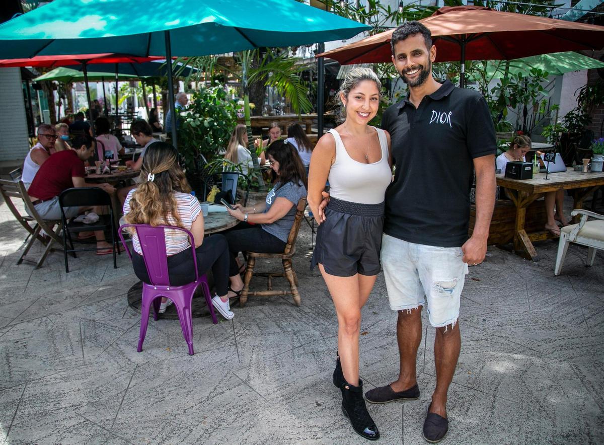 Husband and wife Ehud Simhi, right, and Ayala Siran Navan, left, in the outside seating area at The Alchemist.