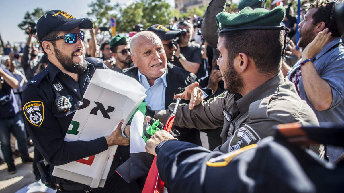An Israeli border police officer pulls a sign from a Palestinian protester outside the new U.S. Embassy in Jerusalem on Monday, May 14, 2018.