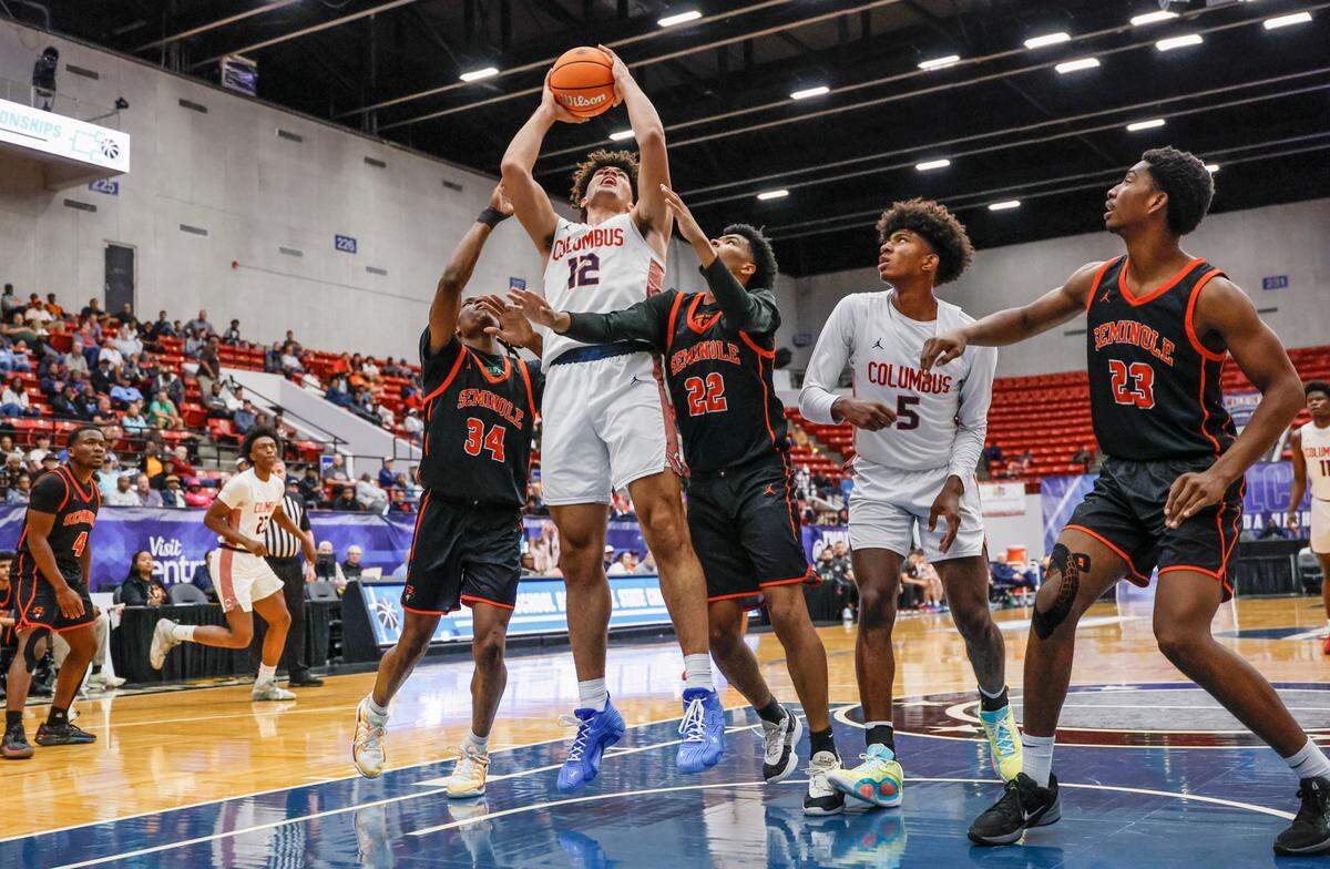 Columbus High School’s Cameron Boozer (12) looks to score as Seminole High School’s Jorein O’Neal (34) and Brayden Tarpley (22) defend in the first half for the FHSAA Class 7A Semi-Final for Boys High School Basketball State Championship