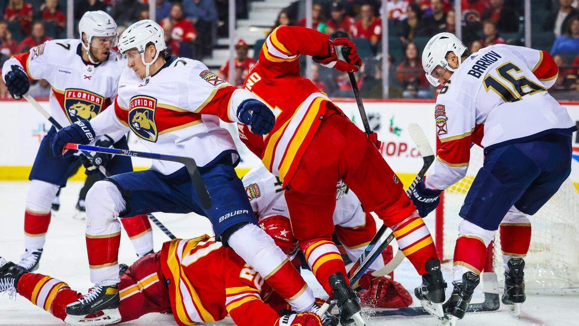Dec 18, 2023; Calgary, Alberta, CAN; Calgary Flames center Blake Coleman (20) and Florida Panthers defenseman Dmitry Kulikov (7) battle for the puck during the third period at Scotiabank Saddledome.